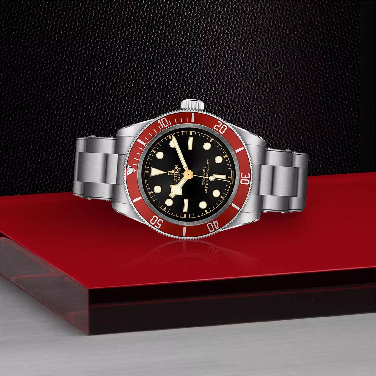 Tudor Black Bay mit Gehäuse und Band aus Edelstahl und schwarzem Zifferblatt und roter Lünette liegend